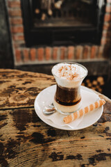 a cup of coffee in a bar, on a vintage rustic wooden table. it is a coffee with chocolate, very sweet