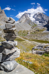 Cairn in front of the Cow lake, Lac des Vaches, in Vanoise national Park, France