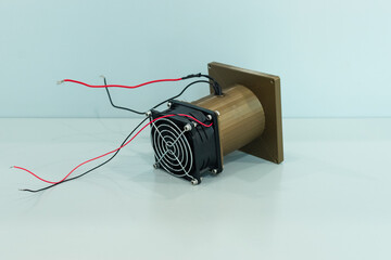 Electrical fan with black and red wires coupled with a golden 3d printed diffuser 