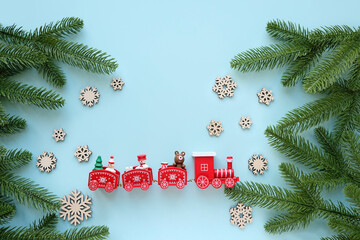 Christmas Train and snowflakes with christmas fir branches on blue background. New Year holiday concept. festive winter seaason. flat lay