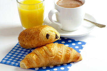 tasse de chocolat chaud et viennoiserie sur une table
