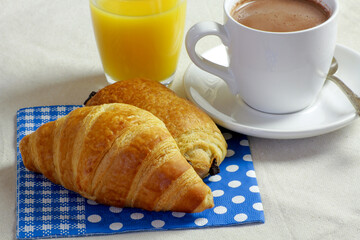 tasse de chocolat chaud et viennoiserie sur une table