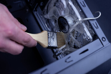 Cleaning a dirty computer fan with a brush