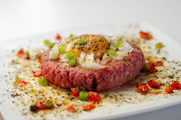 Beef steak tartare with raw egg yolk and onion with tomato