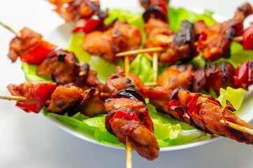 Grilled skewers with chicken, zucchini, mushrooms, peppers and onions served on iceberg lettuce