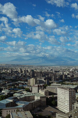 Majestic view of Yerevan city with buildings on background of mountains on sunny day 