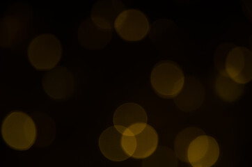 Abstract pattern of golden bokeh garland lights on a dark background