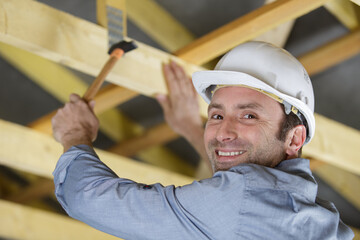 worker roofer builder working on roof structure on construction site