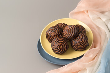 Traditional Russian vanilla marshmallows in chocolate glaze in blue and yellow plates on gray background