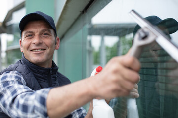 young man washing window view through glass
