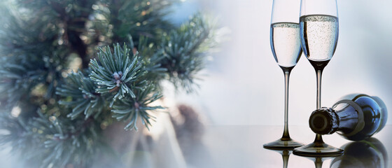Champagne for christmas celebration with two glasses. Winter decoration with pine branches on modern table. Background with short depth of field and space for text.