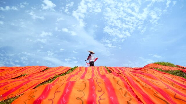 Indonesia 2 December 2020: drying batik against a blue sky background. making batik in a typical Solo color, drying batik background cloth
