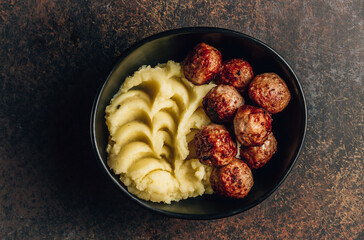 Swedish meatballs with mashed potatoes, gravy and lingonberry jam on dark background. Top view