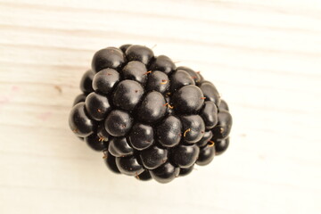 Ripe organic blackberries, close-up, on a wooden table.