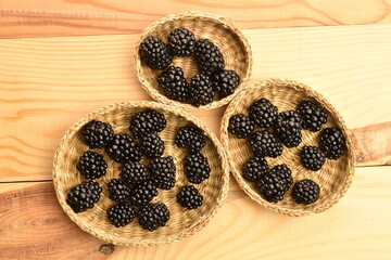 Ripe organic blackberries, close-up, on a wooden table.