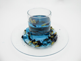 blue anchan tea with triplicate clitoris flowers in a transparent glass Cup on a white background