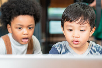 Diversity kid watching cartoon on laptop. African American black boy and Asian friend learning and playing together. interracial friendship concept