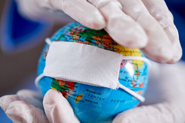 doctor holding globe with protective mask
