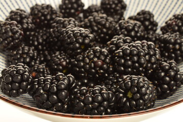Organic blackberries in a ceramic plate, close-up.