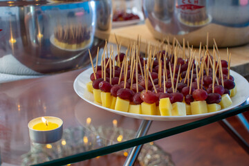 Plate with fruits and cheese on a toothpicks - 396635886