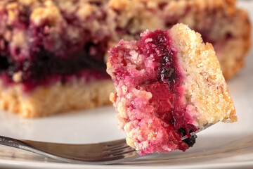 Close up of a little bite of berries crumble pie on a fork.