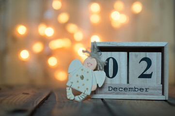 Cube wooden calendar showing date on 2th December with Angel over bokeh background. Advent calendar, Christmas background, Copy space