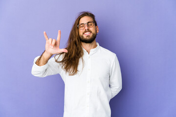 Young man with long hair look showing a horns gesture as a revolution concept.