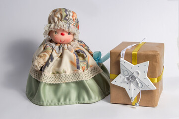 little doll with long dress with christmas gift isolated on white background