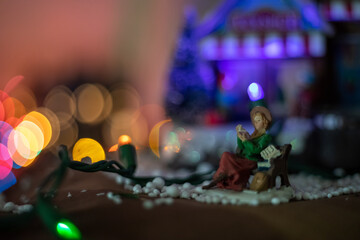 Persona de cerámica para decoración navideña iluminada con bokeh de fondo