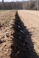 Furrow of brown earth on a sunny day. Sand