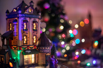 Pequeña casa para decoración navideña de jengibre iluminada con bokeh de fondo