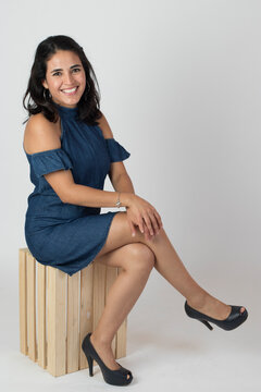 mujer joven en vestido azul sentada en huacal de madera