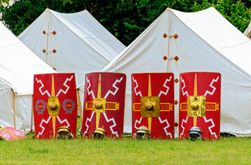 camp of the 13th legion with white tents, shields and helmets at an event in the roman town of...