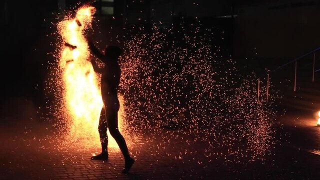 Anonymous person dancing with fire at night