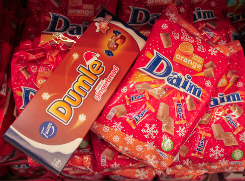 Moscow, Russia, September 2019: limited edition Christmas chocolates Dumle and Daim by Fazer with gingerbread and orange filling in a box and in bright red bags in IKEA store