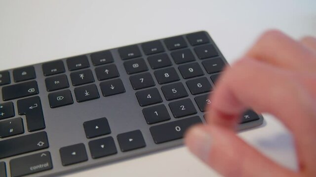 person typing on keyboard on numeric pad