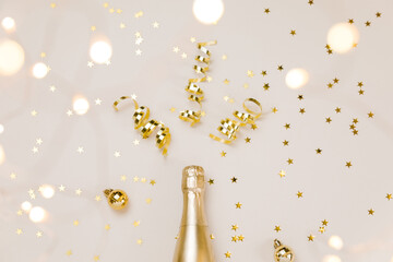 Creative Christmas and New Year composition with golden champagne bottle, confetti stars, party...