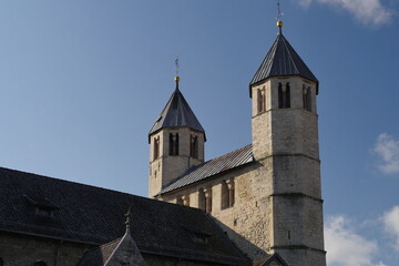 The towers of the west work, seen from the northeast, of the Lutheran collegiate church of Bad Gandersheim Germany. Construction began in year 881. Some Carolingian walls have been preserved - obrazy, fototapety, plakaty