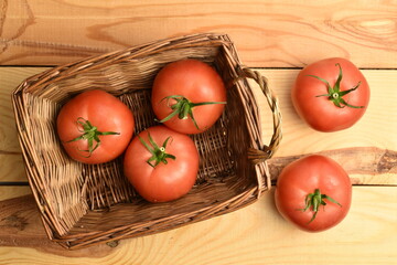 Ripe pink tomatoes, close-up, on a white wooden table.