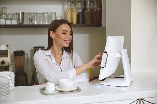 Smiling Young Barista Woman Prints Order On Monitor