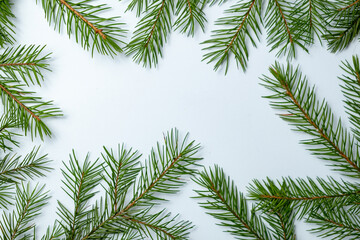 Fototapeta na wymiar Simple Christmas and New Year background with green spruce branches. Copy space and top view.