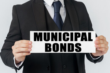 Obraz premium A businessman holds a sign in his hands which says - MUNICIPAL BONDS