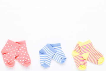 Baby socks on white wooden table