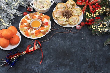 Christmas new year dishes, traditional festive salad olivier and cheese with tomatoes, grapes and honey with fir branches and cones and decorations, dish design idea, selective focus,