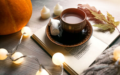 Christmas, festive composition. A cup of coffee and wrestling lights on the table. Winter Christmas decor. Festive atmosphere. Warm colors, soft focus.