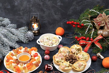 Fototapeta na wymiar Christmas new year dishes, traditional festive salad olivier and cheese with tomatoes, grapes and honey with fir branches and cones and decorations, dish design idea, selective focus,