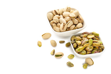 Tasty pistachios in bowls on white background