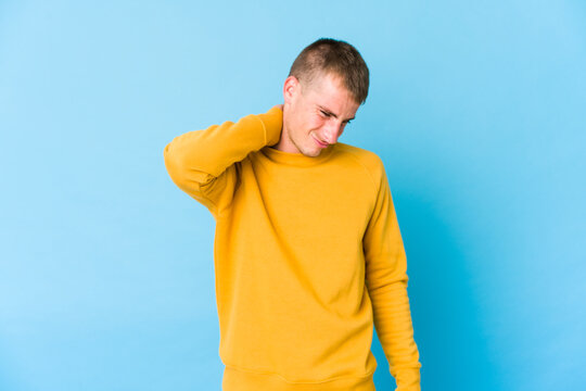 Young caucasian handsome man suffering neck pain due to sedentary lifestyle.