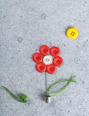 Sewing theme creative flat lay design: flower in a flower pot under the sun made of needle, thread,...
