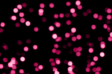 Blurry colored Christmas holiday lights on a black background.